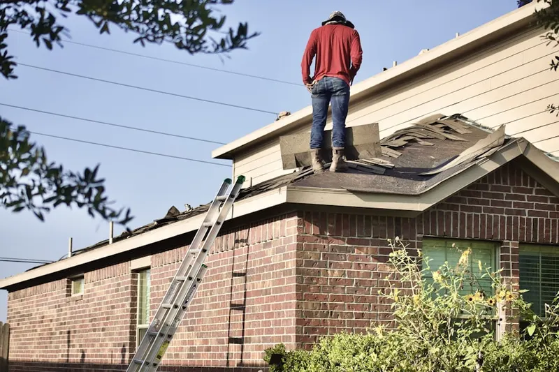 Professional roofer working on a residential roof in Coolidge Corner